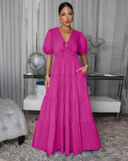 Pink tiered maxi dress with puff sleeves and V-neck, cinched bodice.