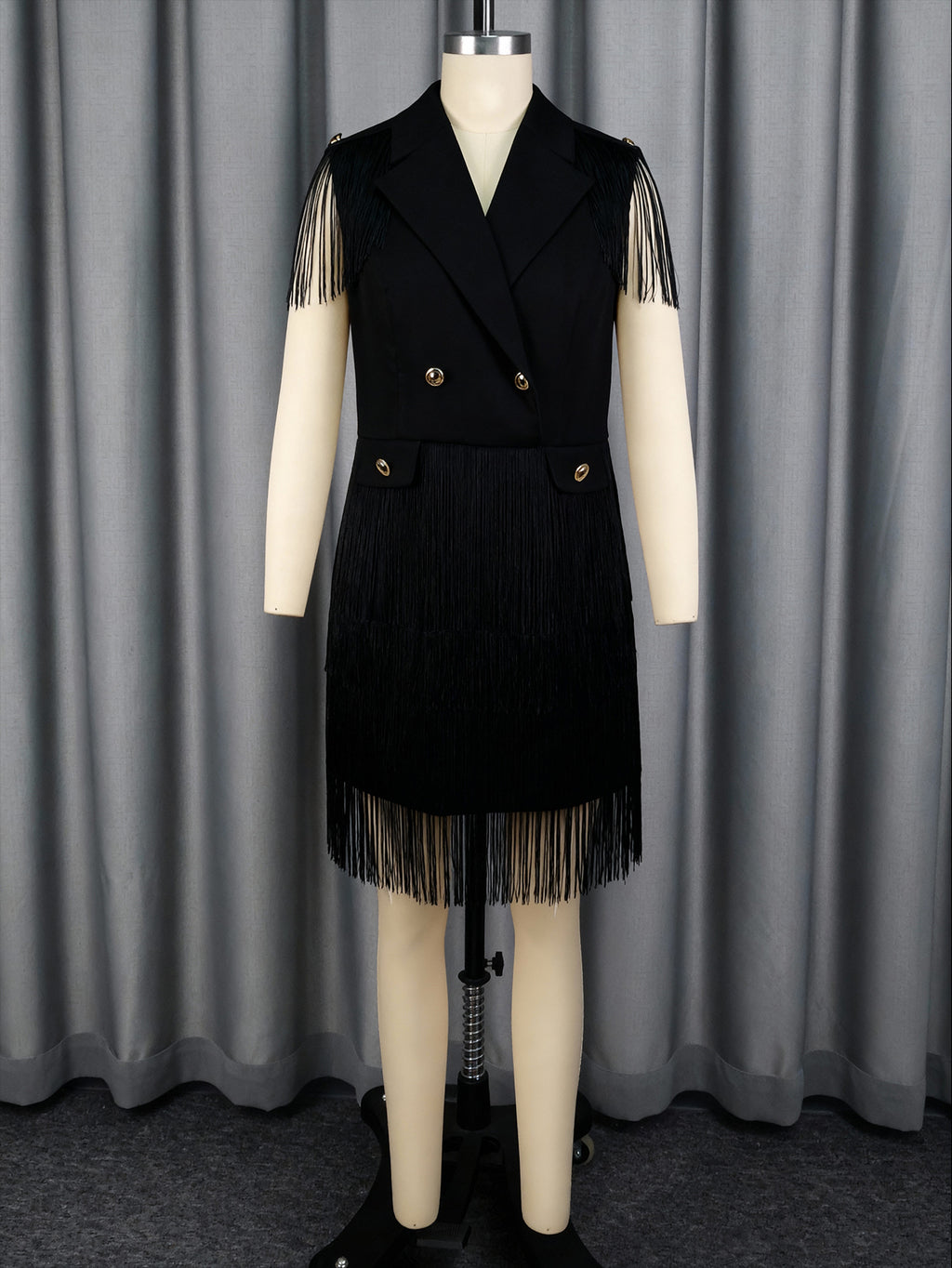 Black V-neck sleeveless dress with gold buttons and tassel fringe skirt