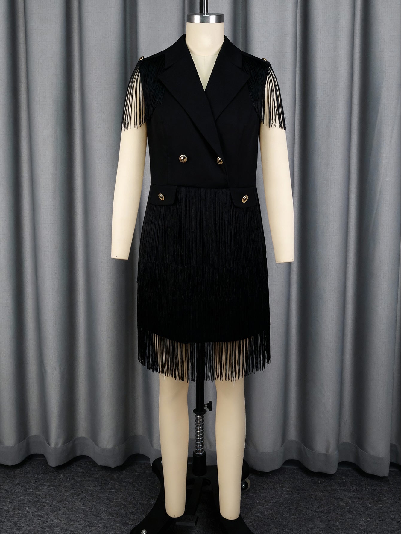 Black V-neck sleeveless dress with gold buttons and tassel fringe skirt