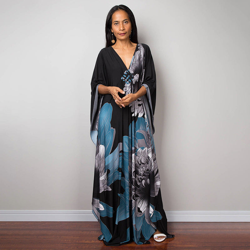 One-piece beach swim dress with V-neck and draped sleeves, black with blue floral print