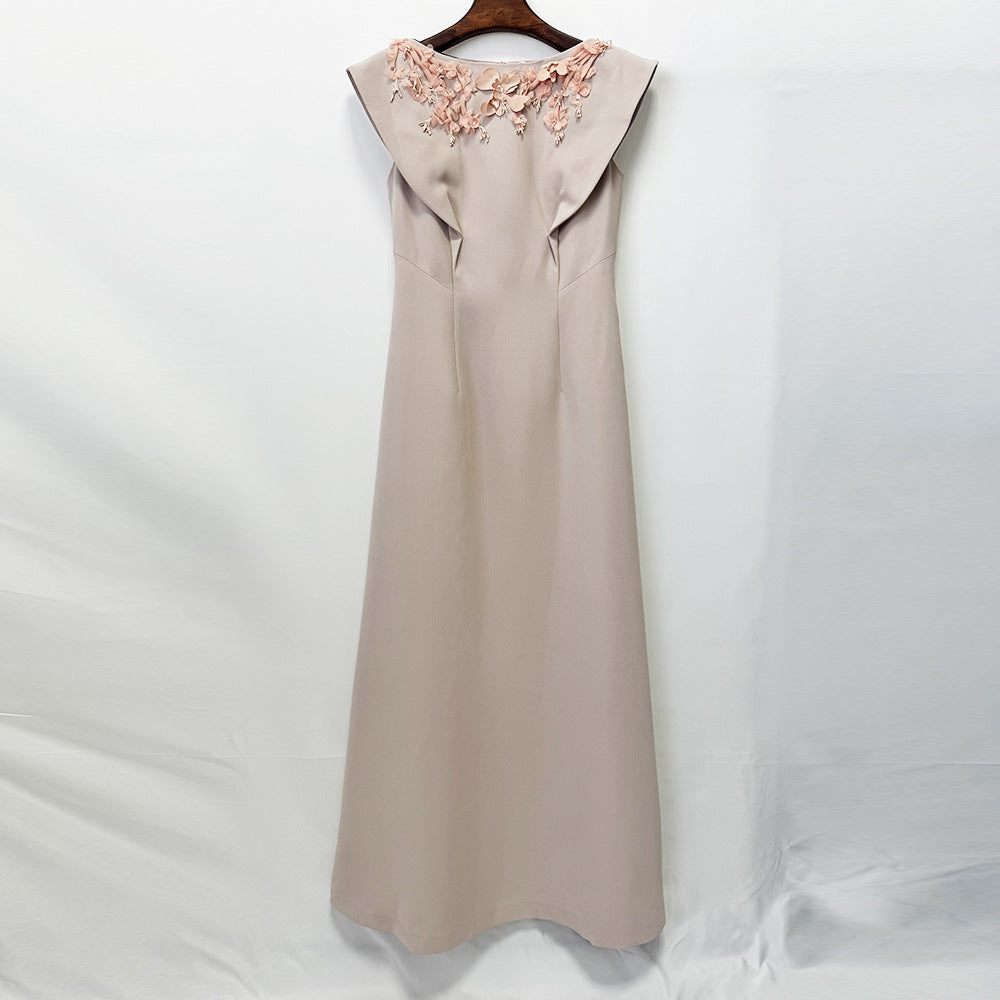 Beige sleeveless maxi dress with floral applique on back yoke, hanging on wooden hanger