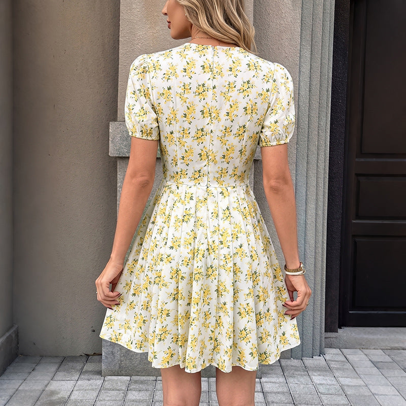 Yellow floral V-neck dress with puff sleeves and gathered back pleats, mid-length