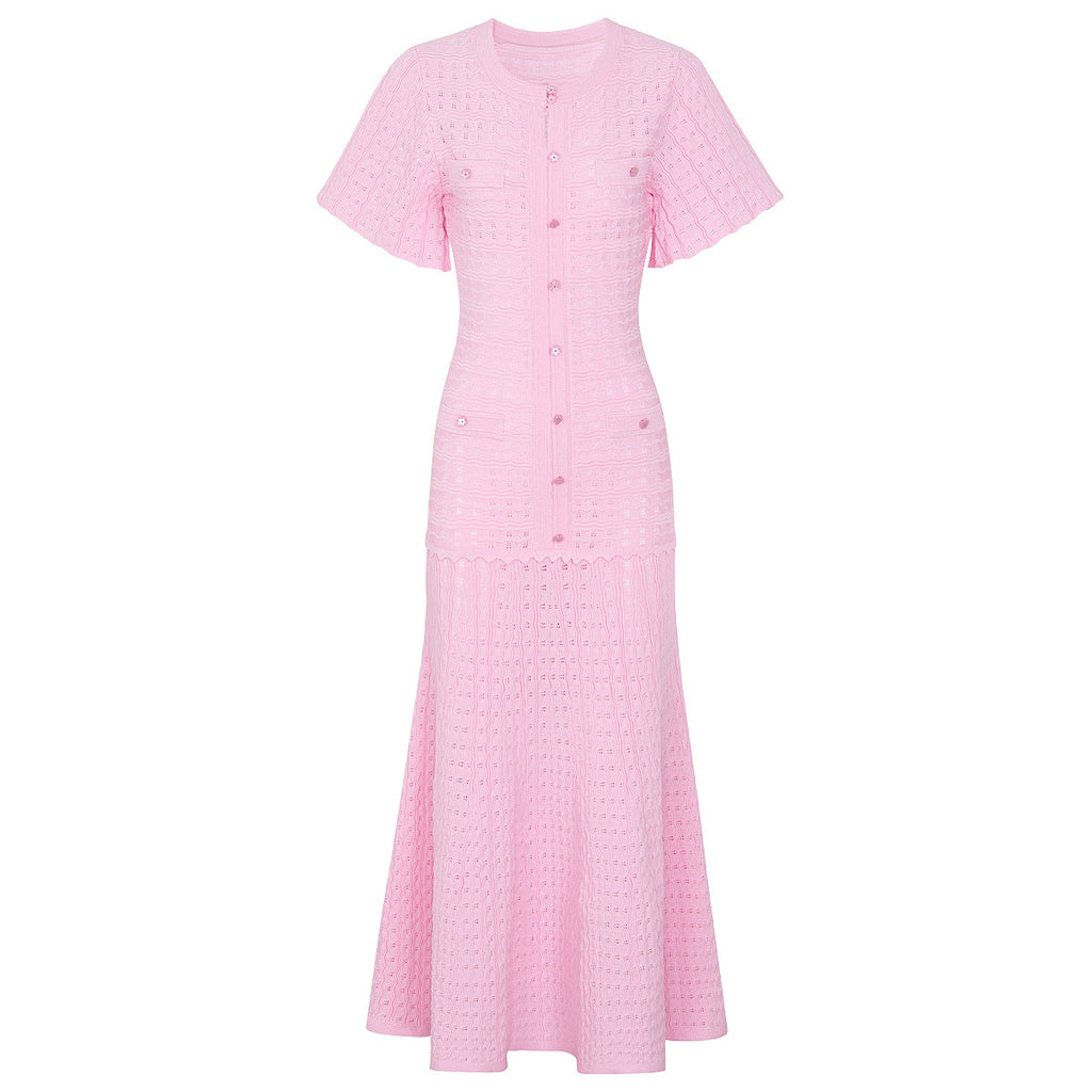 Pink maxi silk dress with short sleeves, fitted button placket, and flared textured skirt.