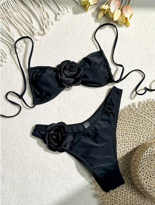 Black one-piece swimsuit with dark rose appliques and thin shoulder straps.