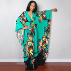 Teal one-piece swim dress with colorful floral print and flowing wide sleeves