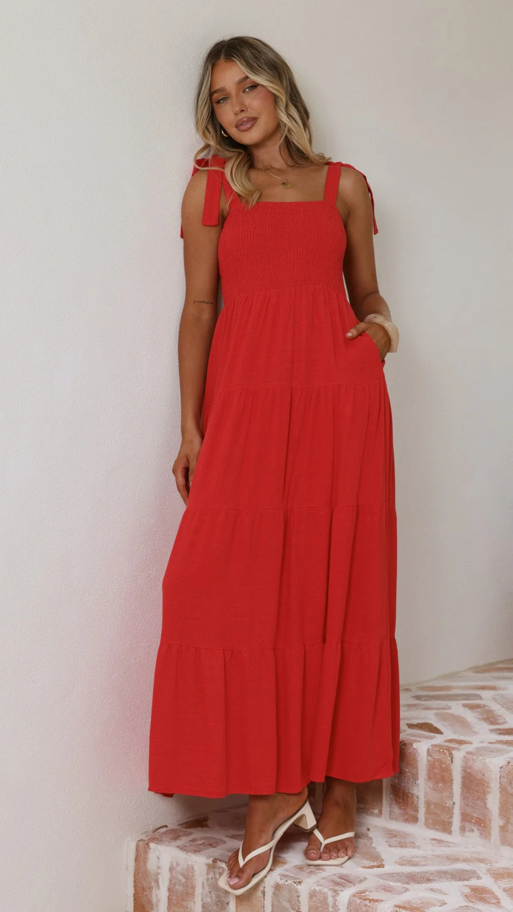 Red sleeveless summer dress with square neckline and tie straps, gathered tiered skirt