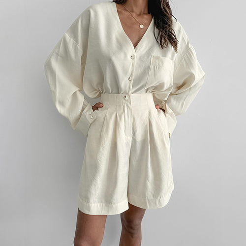 Ivory button-front pajama romper with V-neck and belted waist, long sleeves
