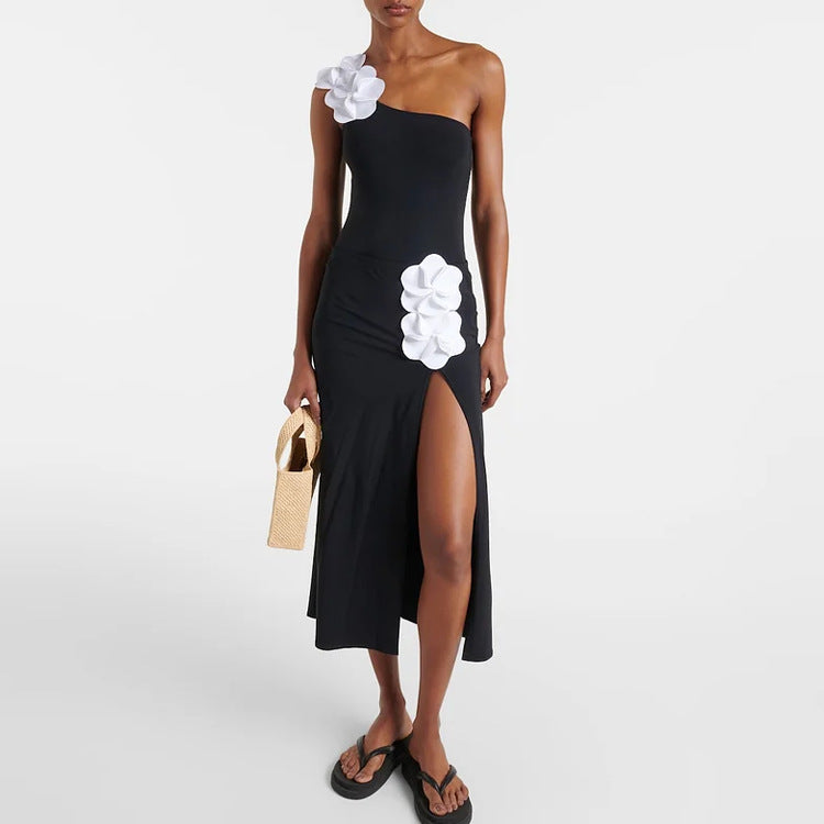 Black one-piece swimsuit, one-shoulder, white flower applique and side-slit skirt
