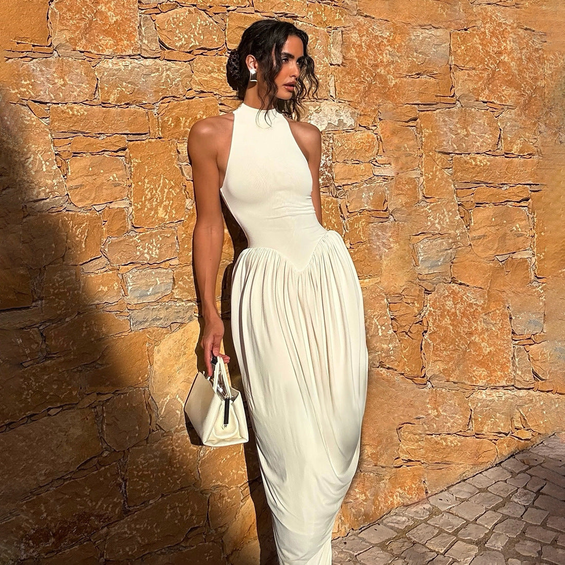 White sleeveless spring dress with high neck and gathered waist, draped skirt