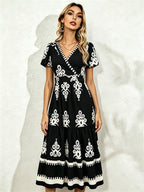 Black midi short-sleeve dress with V-neck and white floral embroidery, tiered skirt