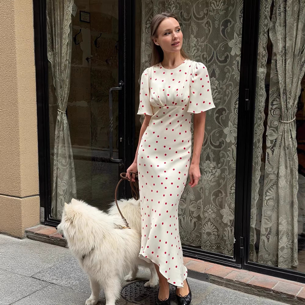 White maxi dress with red polka dots, short sleeves, fitted silhouette, front slit