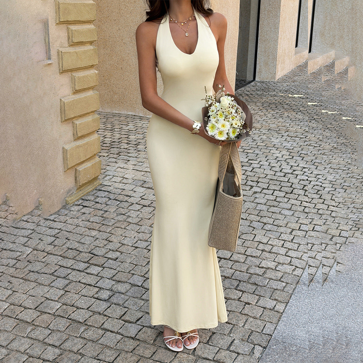 Cream sleeveless halter maxi dress with fitted bodice and V-neck front
