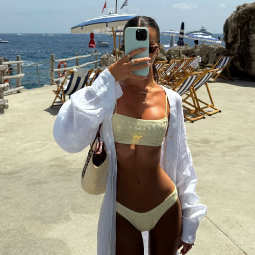White bandeau one-piece swimsuit with studded detail and matching high-cut bottoms