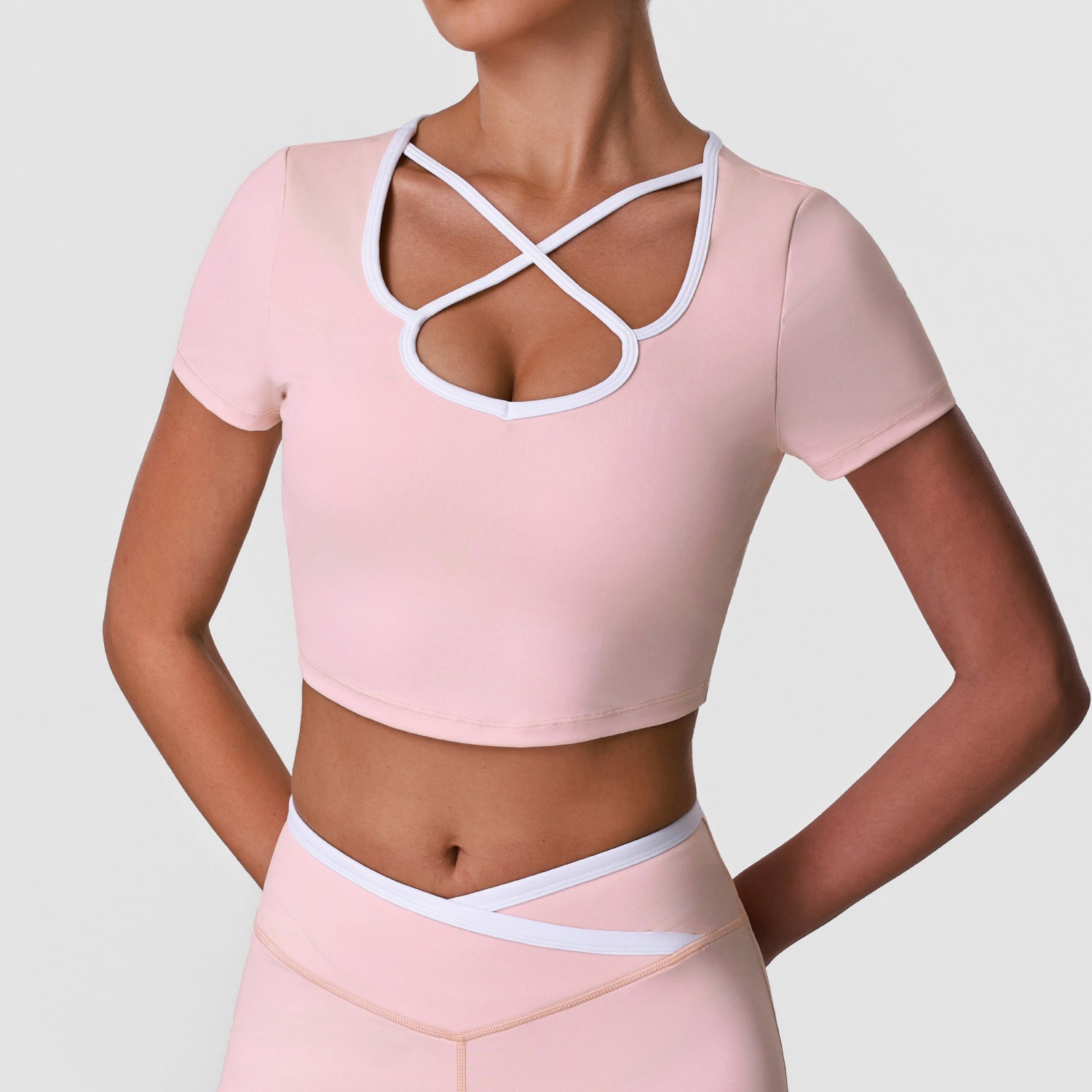 Women's sports crop top, light pink with crisscross keyhole chest cutout, short sleeves