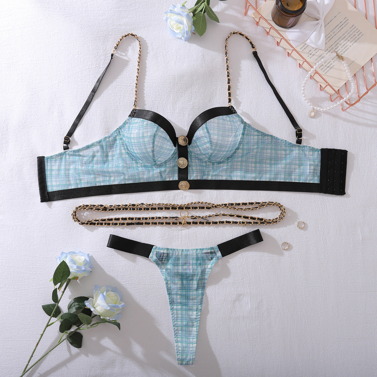 Flat lay blue plaid lingerie set: bra, thong, and long metal chain straps
