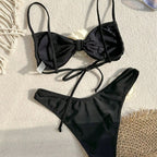Black bikini set with bow-tie front and high-cut bottoms, white flower detail
