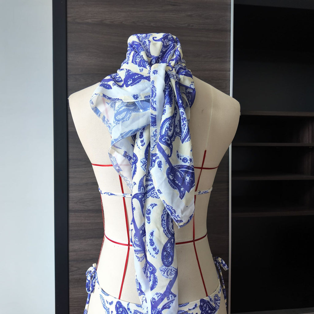 Printed lace bikini set with draped matching headscarf on mannequin, blue-and-white pattern