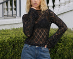 Black long-sleeve knit sweater top with diamond cutout pattern and fitted cuffs