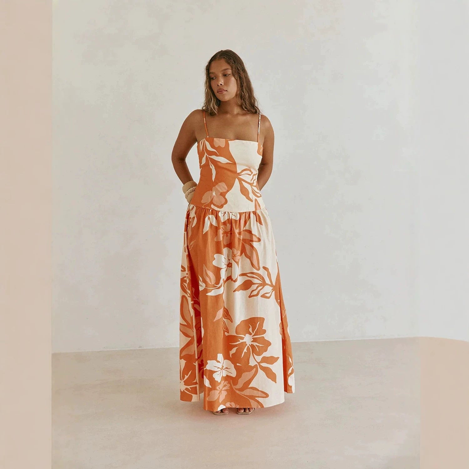 Orange and white floral maxi dress with thin straps and flared gathered skirt