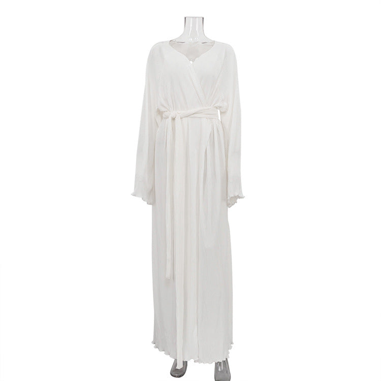 White women's maxi pleated dress on mannequin, V-neck, long flowing sleeves, tied belt
