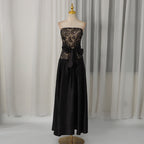 Black strapless summer dress on mannequin with embroidered bodice and waist bow