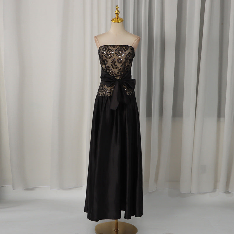 Black strapless summer dress on mannequin with embroidered bodice and waist bow