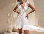 White one-piece swimwear with scalloped lace straps and tiered mini skirt