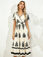 Cream midi short-sleeve dress with V-neck and black floral embroidery, tiered skirt