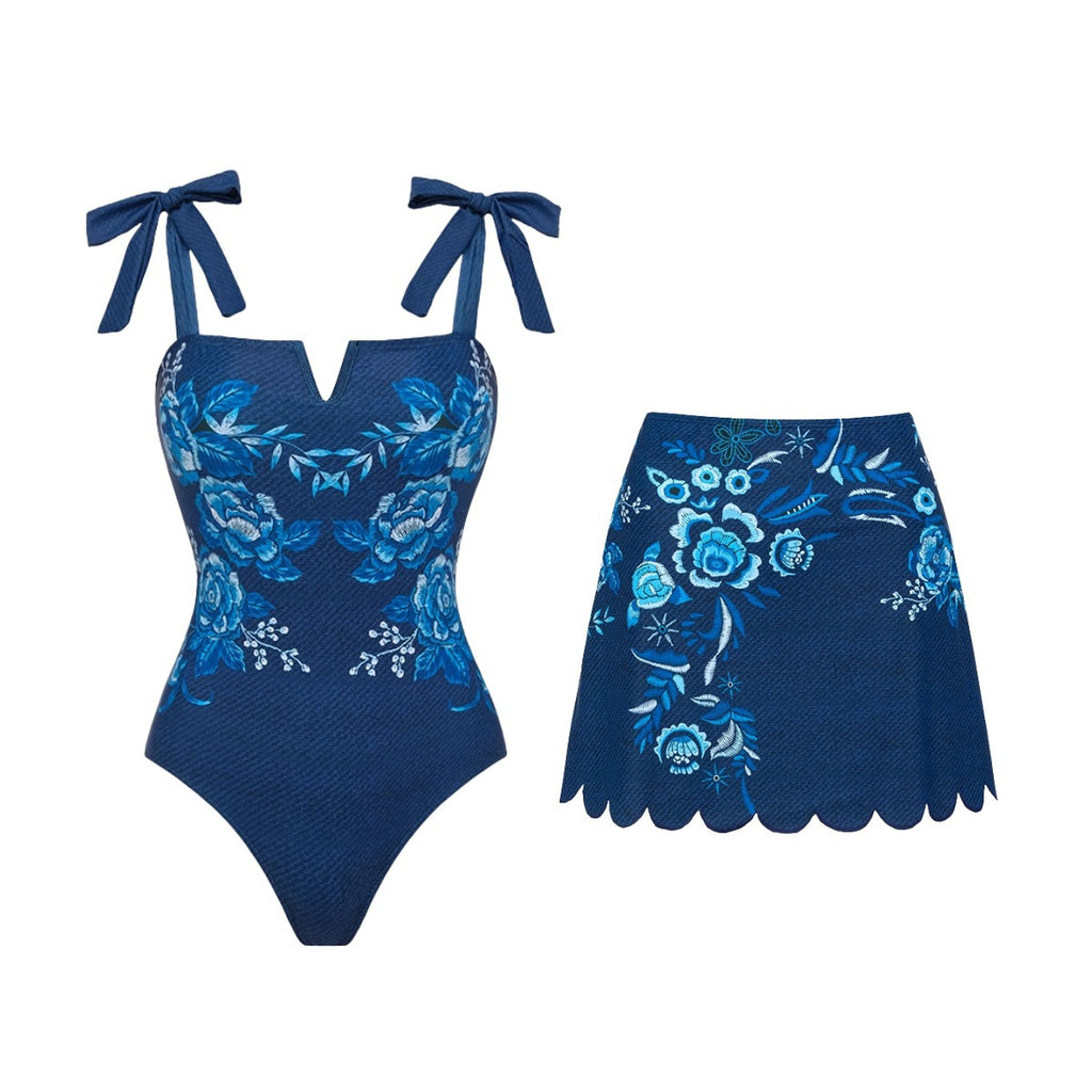 Blue floral one-piece swimsuit with bow straps and scalloped skirt bottom