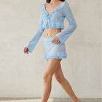 Light blue one-piece swimwear with ruffled V-neck and tiered mini skirt, long sleeves