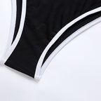Black swimsuit close-up with white piping along curved side