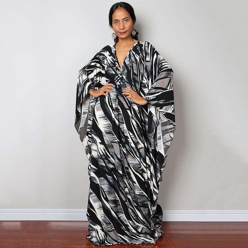 Black and white zebra-striped one-piece swim dress with V-neck and draped sleeves