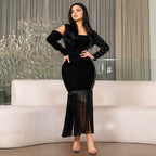 Black long-sleeve bodycon dress with cutout shoulder and fringed trumpet hem