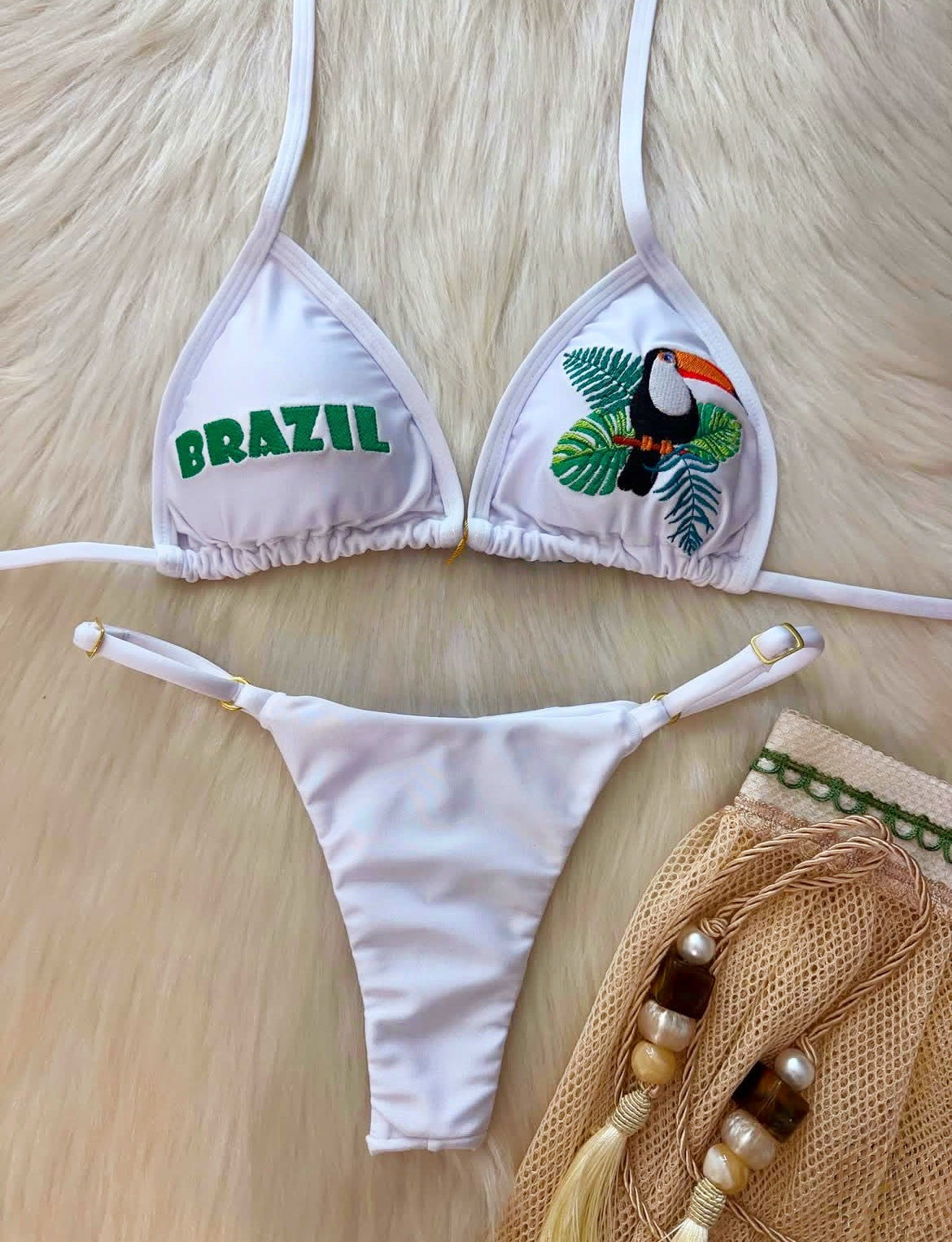 White triangle bikini swimwear with 'BRAZIL' lettering and toucan animal embroidery