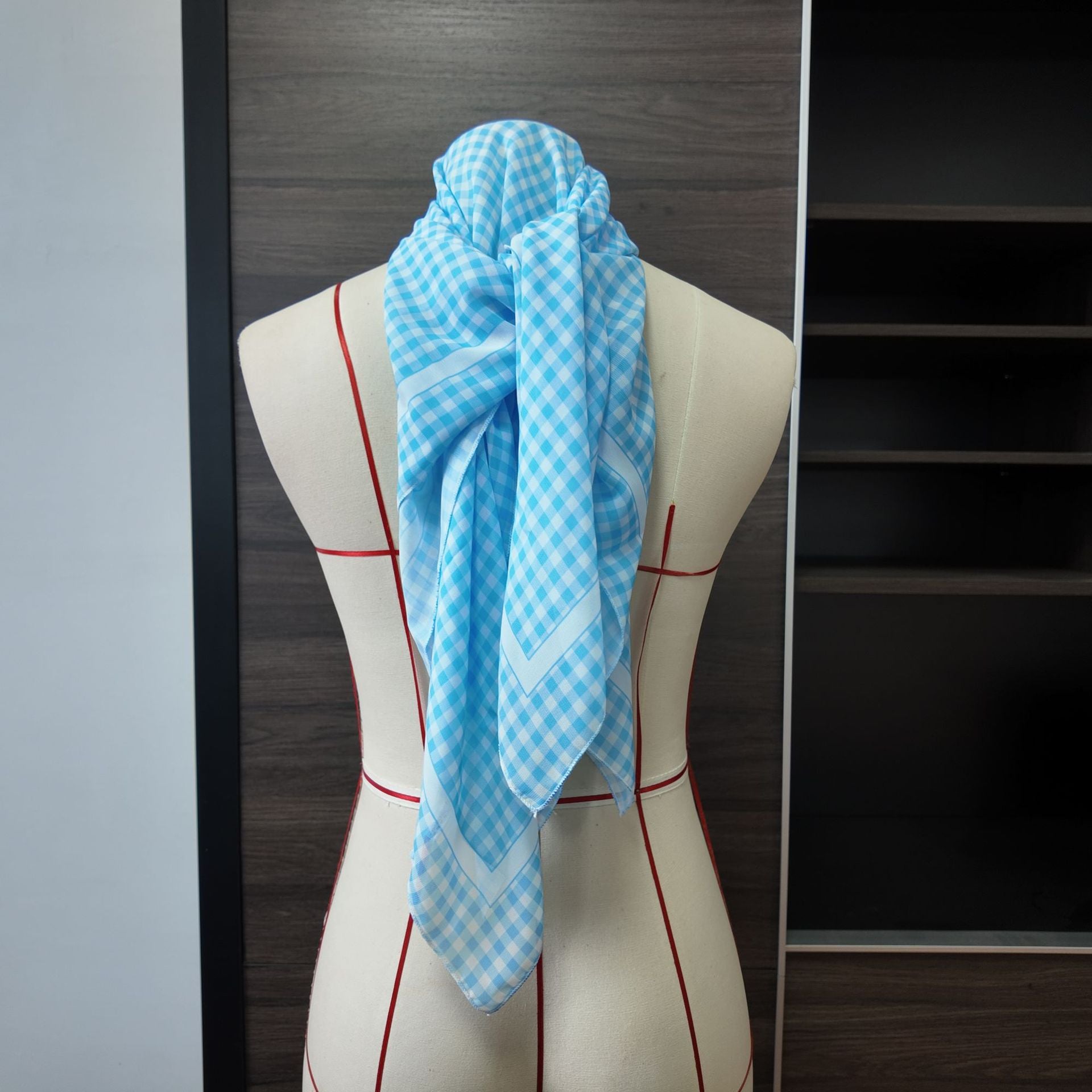 Blue plaid one-piece swimwear with matching scarf draped over chest