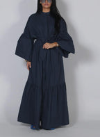 Navy lace long-sleeve dress with draped sleeves, bow waist, and tiered maxi skirt