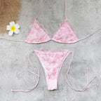 Pink lace triangle bikini top and matching tie-side bottom, flat lay