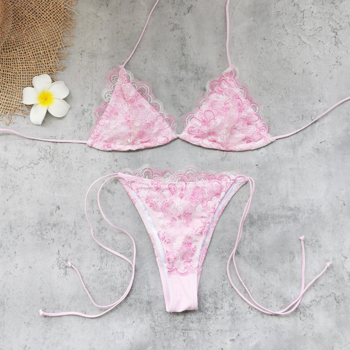 Pink lace triangle bikini top and matching tie-side bottom, flat lay