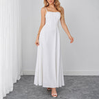 White sleeveless maxi dress with spaghetti straps and fitted bodice.
