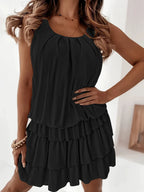 Black ruffled sleeveless dress with tiered skirt and gathered round neckline
