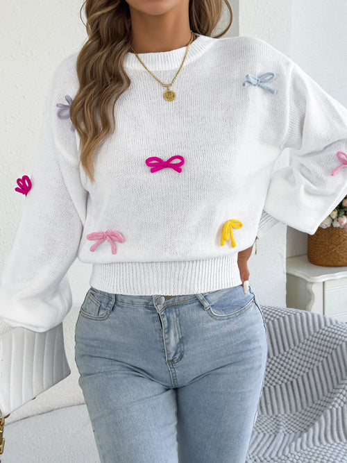 White knit sweater with bow accents, lantern sleeves, and fitted waist