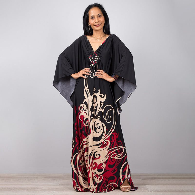 One-piece beach swim dress with V-neck, draped sleeves, and black floral scroll print