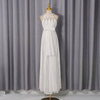 White sleeveless spring dress on mannequin, lace halter bodice and belted waist, tiered skirt