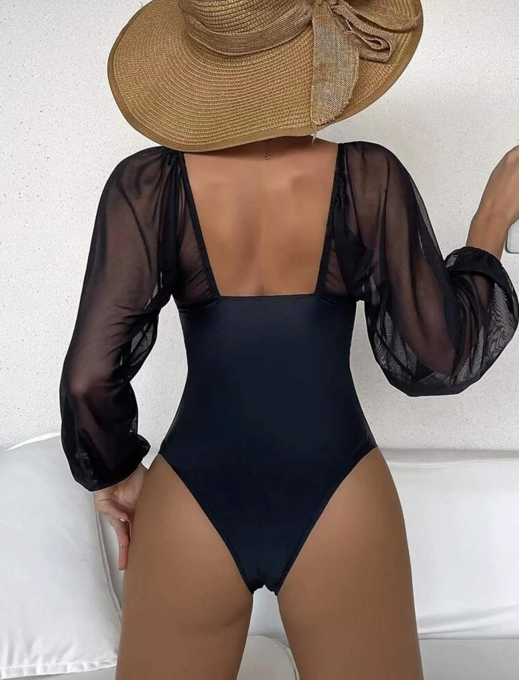Black one-piece swimsuit with sheer long puff sleeves and scoop back