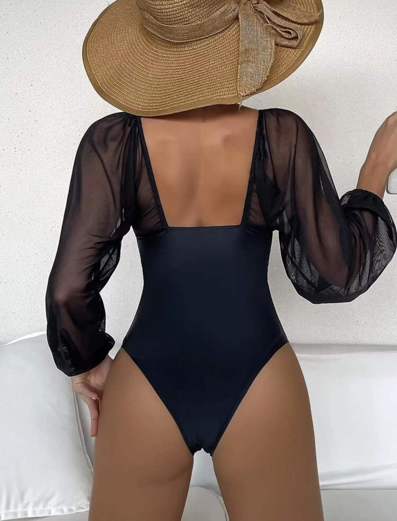 Black one-piece swimsuit with sheer long puff sleeves and scoop back