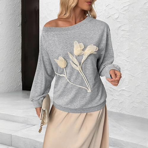 Gray off-shoulder long sleeve top with 3D floral appliqué