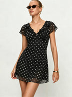 Black polka dot mini dress with ruffle neckline and short puff sleeves, A-line