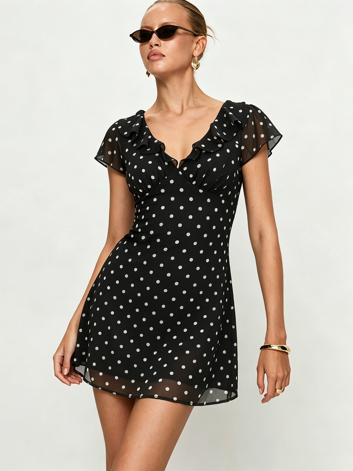 Black polka dot mini dress with ruffle neckline and short puff sleeves, A-line