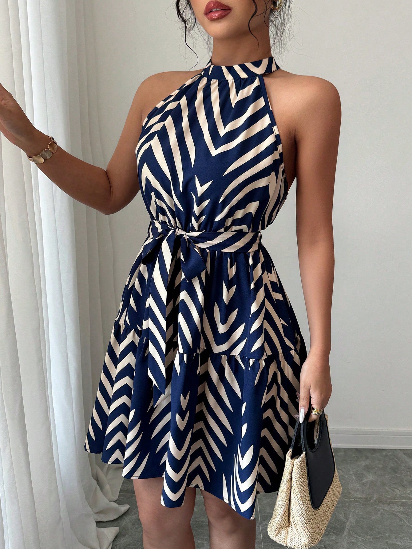 Striped halter dress in blue and white zigzag print with cinched waist and flared skirt