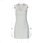 White lace bodycon mini dress on mannequin with scalloped neckline and dark dot print